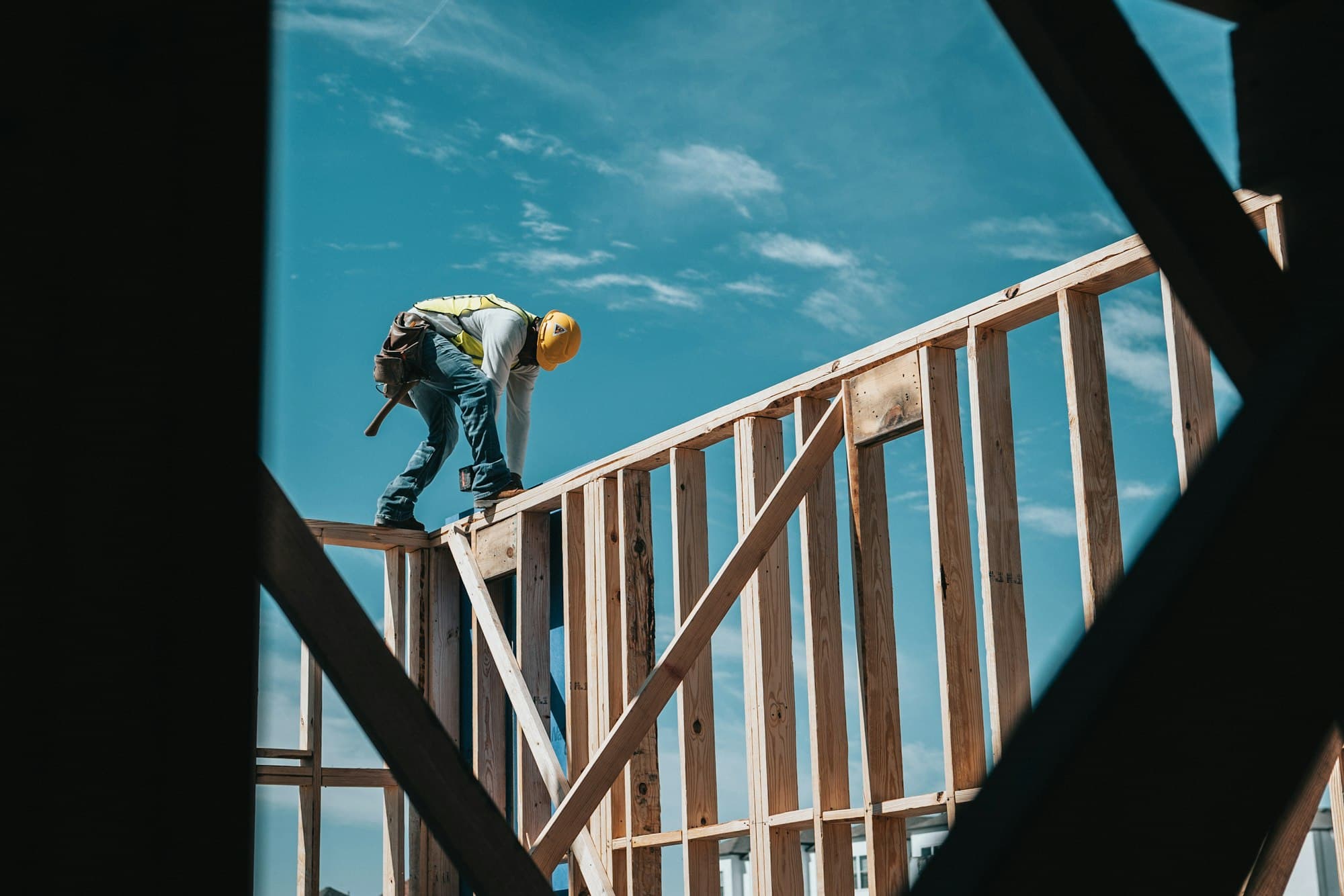 Construction worker on the timber frame of a house under an open sky